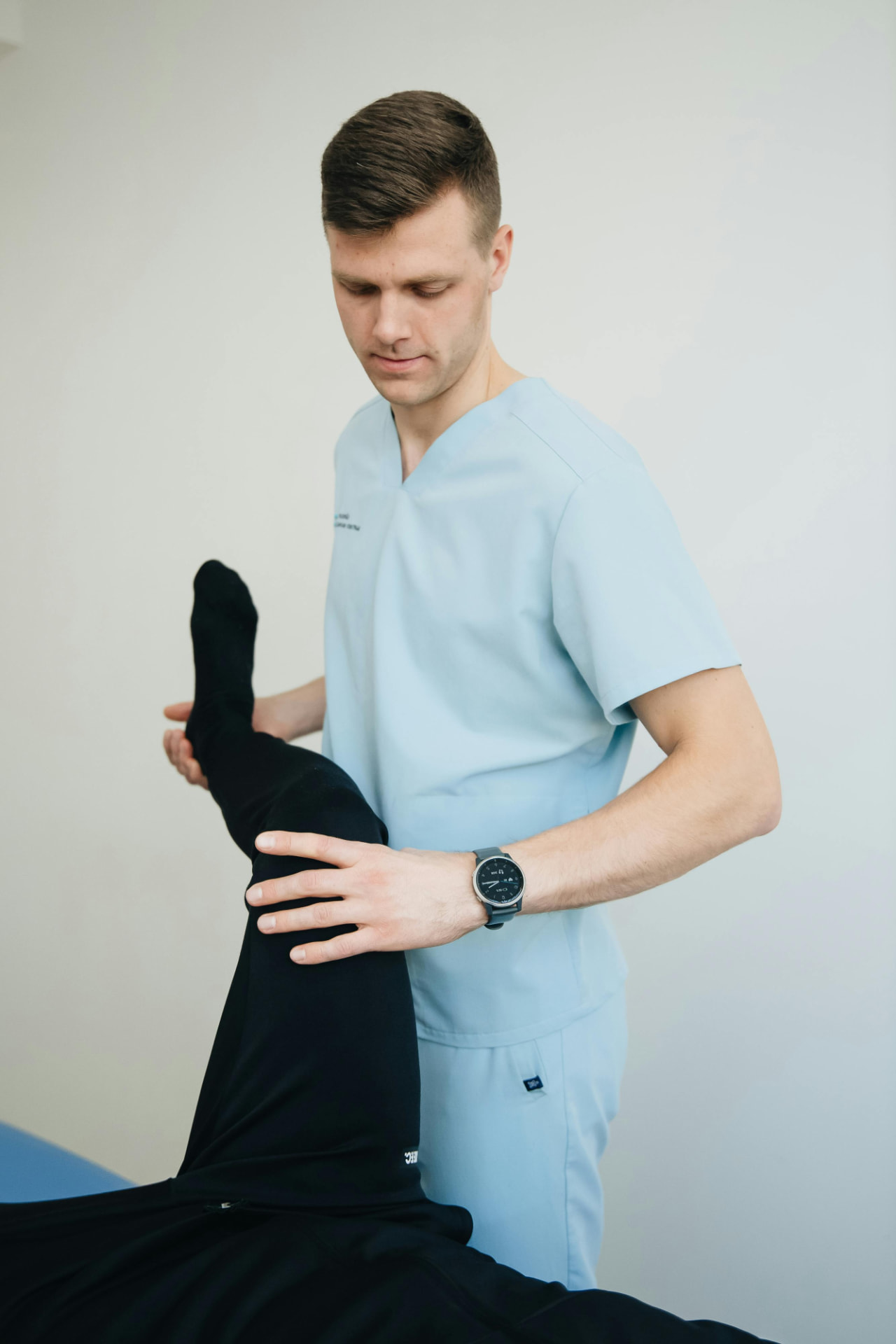 Physical therapist assisting a patient with leg stretches