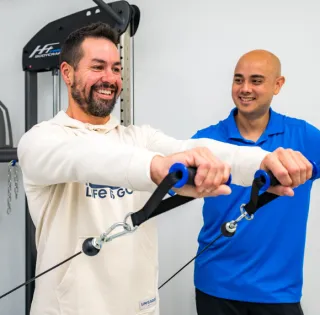 Therapist coaching a patient through cable resistance training