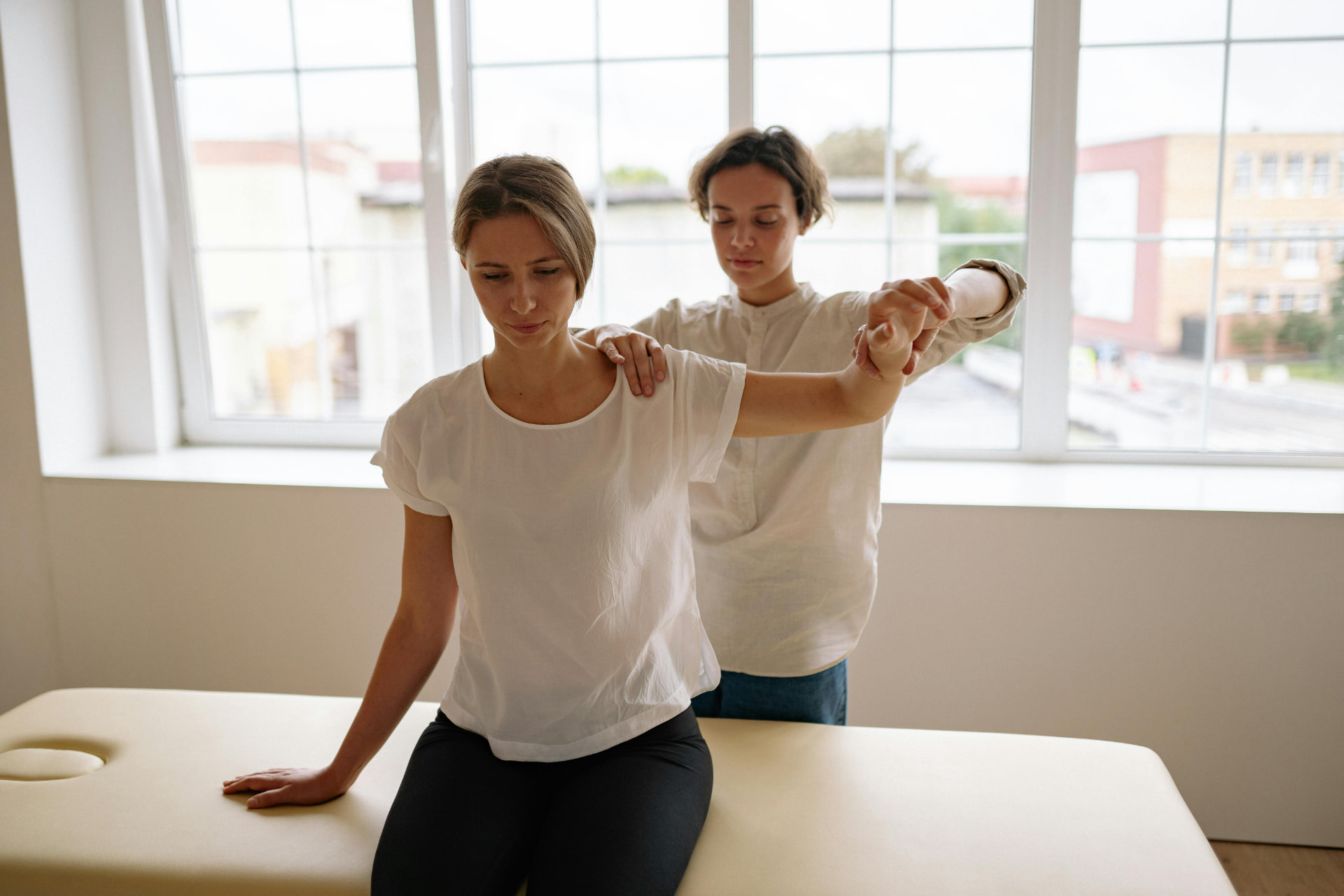 Physical therapist performing manual therapy on a patient's shoulder